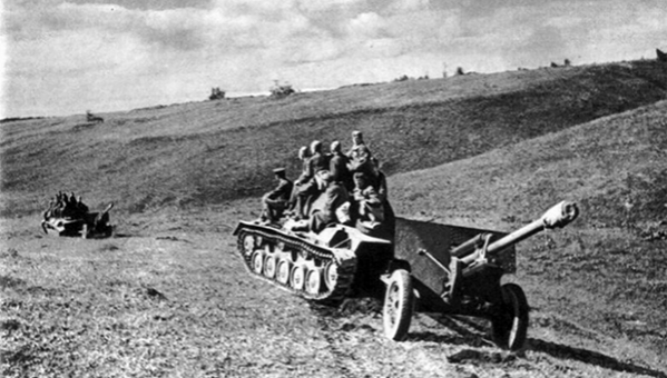 Артиллерийский расчет пушки ЗИС-3 на броне танка выдвигается на позицию