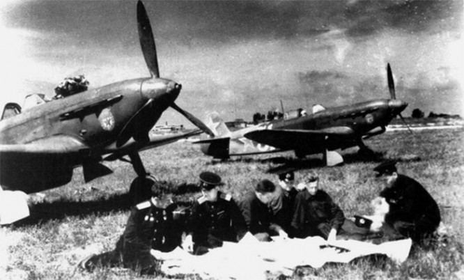 Летчики ВВС Черноморского флота изучают карту района боевых действий на аэродроме у самолетов Як-9Д