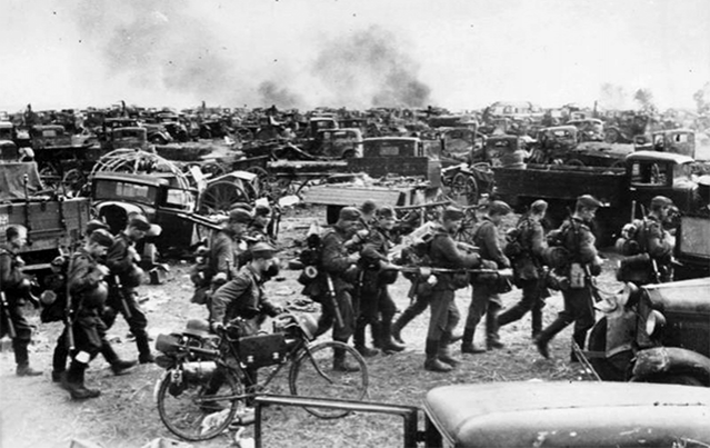Немецкая пехота проходит мимо брошенных под Киевом советских грузовиков, 1941 год